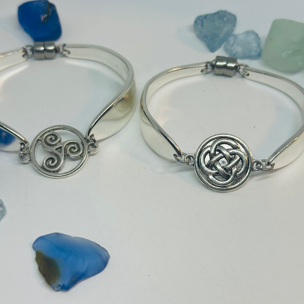 Two Lady Hamilton 1932 vintage spoon bracelets side by side: one with a triskele charm, one with a Celtic knot charm.